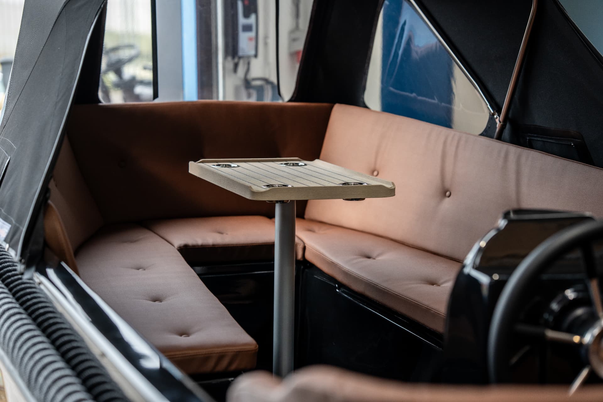 Interieur van een tender met bruine bekleding en tafeltje